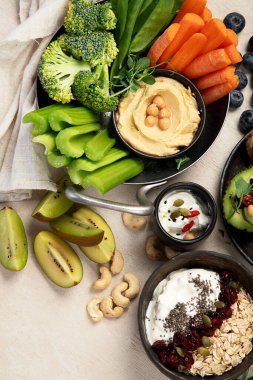 Çeşitli humus sosları. Sebzeli humus tabağı. Havuç, kereviz çubukları. Vejetaryen ve geleneksel humus hafif bir arka planda sağlıklı ve vejetaryen atıştırmalığı gibidir. Üst görünüm.