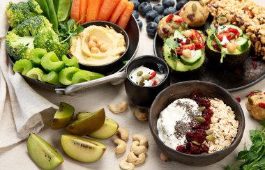 Çeşitli humus sosları. Sebzeli humus tabağı. Havuç, kereviz çubukları. Vejetaryen ve geleneksel humus hafif bir arka planda sağlıklı ve vejetaryen atıştırmalığı gibidir. Üst görünüm.