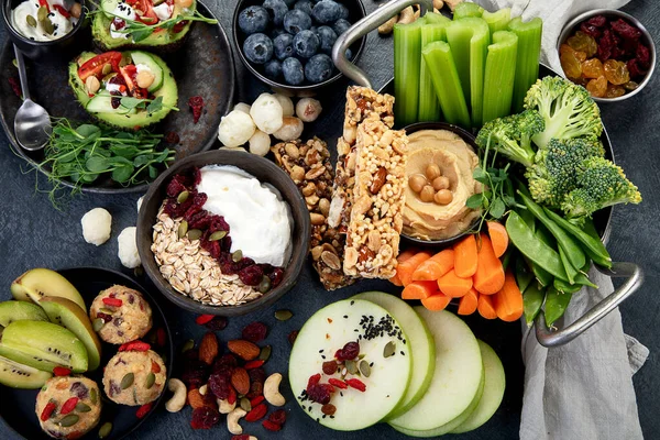 Çeşitli humus sosları. Sebzeli humus tabağı. Havuç, kereviz çubukları. Vejetaryen ve geleneksel humus karanlık bir arka planda sağlıklı ve vejetaryen atıştırmalığı gibidir. Üst görünüm.