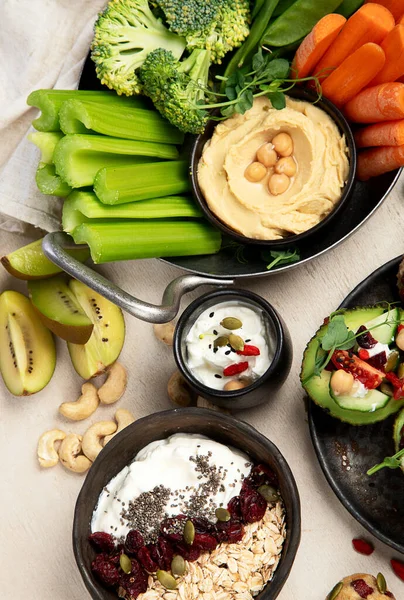 Çeşitli humus sosları. Sebzeli humus tabağı. Havuç, kereviz çubukları. Vejetaryen ve geleneksel humus hafif bir arka planda sağlıklı ve vejetaryen atıştırmalığı gibidir. Üst görünüm.