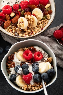 Sağlıklı kahvaltı gevreği kasesi ev yapımı granola taze ahududu, yaban mersini ve chia tohumlu diyet beslenme konsepti. 