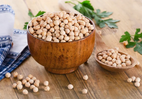 Chickpeas in bowl on wooden background — Stock Photo, Image