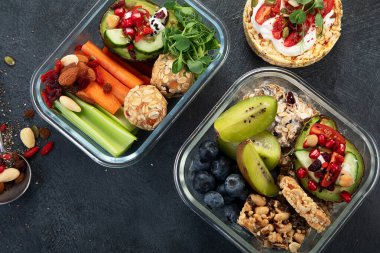 Çeşitli sağlıklı besleyici yemekleri olan beslenme çantaları. Sağlıklı abur cubur kavramı karanlık bir arka planda kutuda. Üst görünüm.