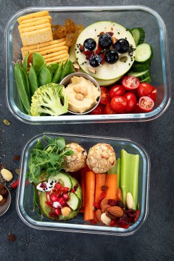 Çeşitli sağlıklı besleyici yemekleri olan beslenme çantaları. Sağlıklı abur cubur kavramı karanlık bir arka planda kutuda. Üst görünüm.