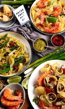 İtalyan makarnası. Etli domates soslu spagetti, deniz ürünleri makarnası, arka planda vejetaryen makarna. Üst görünüm.