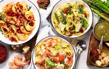 İtalyan makarnası. Etli domates soslu spagetti, deniz ürünleri makarnası, arka planda vejetaryen makarna. Üst görünüm.