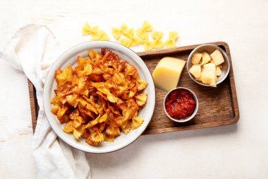 Ev yapımı Moda Makarna Cips. Hafif arka planda parmesanlı çıtır Baharatlı Pasta Farfalle. Üst görünüm.