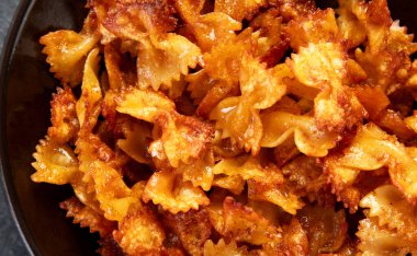 Ev yapımı Moda Makarna Cips. Hafif arka planda parmesanlı çıtır Baharatlı Pasta Farfalle. Üst görünüm.