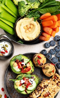 Çeşitli humus sosları. Sebzeli humus tabağı. Havuç, kereviz çubukları. Vejetaryen ve geleneksel humus hafif bir arka planda sağlıklı ve vejetaryen atıştırmalığı gibidir. Üst görünüm.