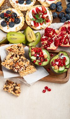 Meyveli, fındıklı ve kuru meyveli sağlıklı çerez tabağı. Gurme organik yiyecekler, temiz yiyecekler, bitki bazlı protein, vegan diyeti. Üst görünüm.