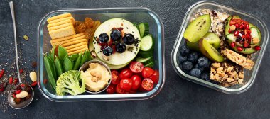 Çeşitli sağlıklı besleyici yemekleri olan beslenme çantaları. Sağlıklı abur cubur kavramı karanlık bir arka planda kutuda. Üst görünüm.