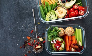 Çeşitli sağlıklı besleyici yemekleri olan beslenme çantaları. Sağlıklı abur cubur kavramı karanlık bir arka planda kutuda. Üst görünüm.