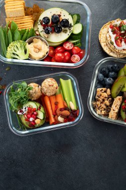 Çeşitli sağlıklı besleyici yemekleri olan beslenme çantaları. Sağlıklı abur cubur kavramı karanlık bir arka planda kutuda. Üst görünüm.