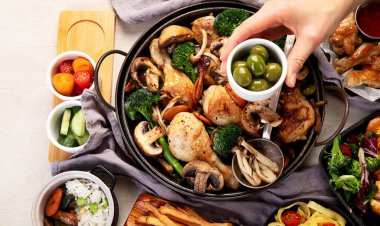 Mantar, havuç ve brokoli ile pişirilmiş tavuk butları hafif bir arka planda kızartma tavasında. Üst görünüm.