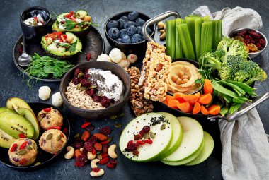 Çeşitli humus sosları. Sebzeli humus tabağı. Havuç, kereviz çubukları. Vejetaryen ve geleneksel humus karanlık bir arka planda sağlıklı ve vejetaryen atıştırmalığı gibidir. Üst görünüm.