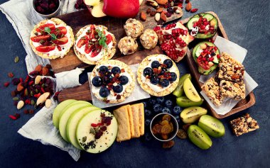 Meyveli, fındıklı ve kuru meyveli sağlıklı çerez tabağı. Gurme organik yiyecekler, temiz yiyecekler, bitki bazlı protein, vegan diyeti. Üst görünüm.