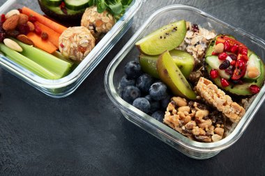 Çeşitli sağlıklı besleyici yemekleri olan beslenme çantaları. Sağlıklı abur cubur kavramı karanlık bir arka planda kutuda. Üst görünüm.