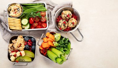 Çeşitli sağlıklı besleyici yemekler. Metal kutularda hafif arka planda sağlıklı atıştırmalık kavramı. Üst görünüm.