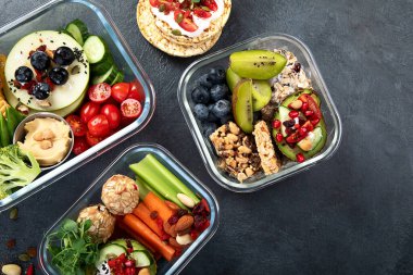 Çeşitli sağlıklı besleyici yemekleri olan beslenme çantaları. Sağlıklı abur cubur kavramı karanlık bir arka planda kutuda. Üst görünüm.