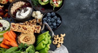 Çeşitli humus sosları. Sebzeli humus tabağı. Havuç, kereviz çubukları. Vejetaryen ve geleneksel humus karanlık bir arka planda sağlıklı ve vejetaryen atıştırmalığı gibidir. Üst görünüm.