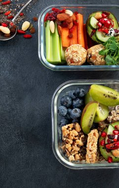 Çeşitli sağlıklı besleyici yemekleri olan beslenme çantaları. Sağlıklı abur cubur kavramı karanlık bir arka planda kutuda. Üst görünüm.