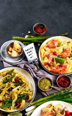 İtalyan makarnası. Etli domates soslu spagetti, deniz ürünleri makarnası, arka planda vejetaryen makarna. Üst görünüm.