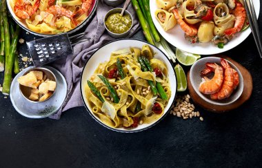 İtalyan makarnası. Etli domates soslu spagetti, deniz ürünleri makarnası, arka planda vejetaryen makarna. Üst görünüm.