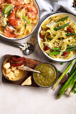 İtalyan makarnası. Etli domates soslu spagetti, deniz ürünleri makarnası, arka planda vejetaryen makarna. Üst görünüm.