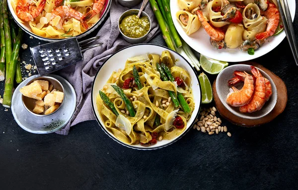 İtalyan makarnası. Etli domates soslu spagetti, deniz ürünleri makarnası, arka planda vejetaryen makarna. Üst görünüm.