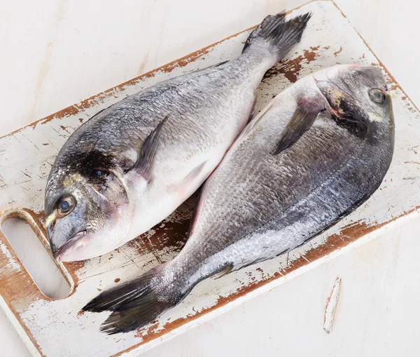 Свіжа риба дорадо на обробній дошці . — стокове фото