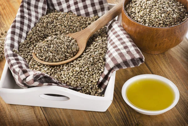 Hemp seeds and oil on a wooden background. — Stock Photo, Image