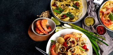İtalyan makarnası. Etli domates soslu spagetti, deniz ürünleri makarnası, arka planda vejetaryen makarna. Üst görünüm.