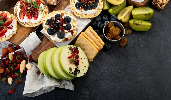 Meyveli, fındıklı ve kuru meyveli sağlıklı çerez tabağı. Gurme organik yiyecekler, temiz yiyecekler, bitki bazlı protein, vegan diyeti. Üst görünüm.