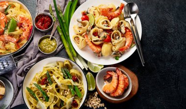 İtalyan makarnası. Etli domates soslu spagetti, deniz ürünleri makarnası, arka planda vejetaryen makarna. Üst görünüm.