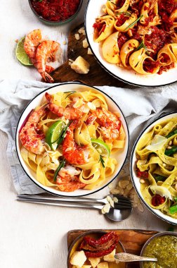 İtalyan makarnası. Etli domates soslu spagetti, deniz ürünleri makarnası, arka planda vejetaryen makarna. Üst görünüm.