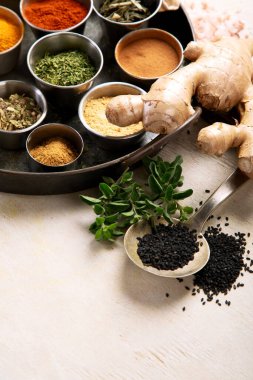 Bir sürü farklı baharat. Hafif bir arka planda çeşitli baharat ve otlardan oluşan bir koleksiyon. Üst görünüm.