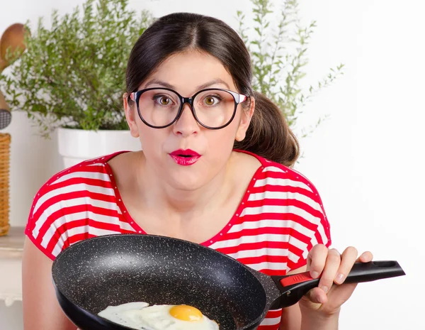 Funny woman holding pan with egg — Stock Photo, Image