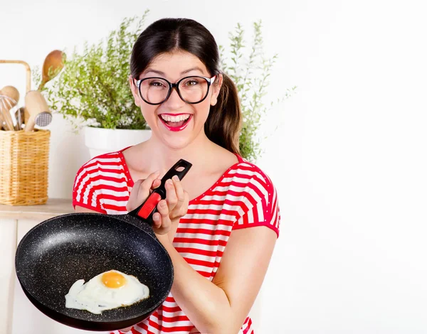 Happy woman holding pan with egg. — Stock Photo, Image