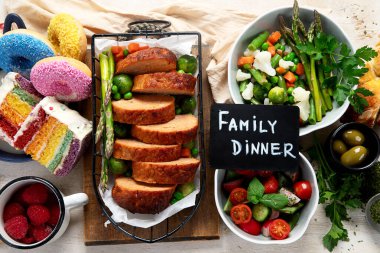 Hafif bir arka planda kızarmış et, pasta ve atıştırmalıklarla aile yemeği. Üst görünüm