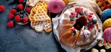 Siyah arka planda lezzetli hamur işleri ve kekler. Üst görünüm.