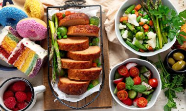 Hafif bir arka planda kızarmış et, pasta ve atıştırmalıklarla aile yemeği. Üst görünüm