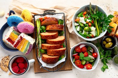 Hafif bir arka planda kızarmış et, pasta ve atıştırmalıklarla aile yemeği. Üst görünüm