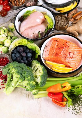 Hafif arka planda pek çok farklı sağlıklı yiyecek. Taze sebze, et, balık, tahıl ve meyve. Üst görünüm.