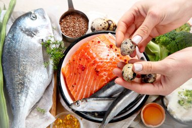 Beyaz arka planda D vitamini bakımından zengin ürünlerle kompozisyon, üst manzara. Doğal D vitamini kaynakları (Balık, peynir, yumurta, mantar)