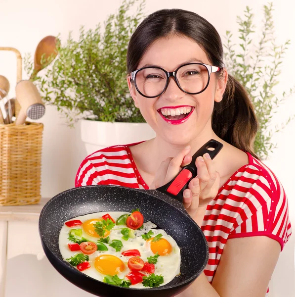 Funny woman holding pan with egg. — Stock Photo, Image