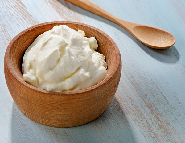 Свежий йогурт в деревянной миске
