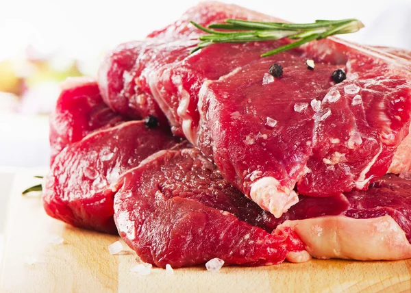 Bife em bruto de carne de bovino na tábua de corte — Fotografia de Stock