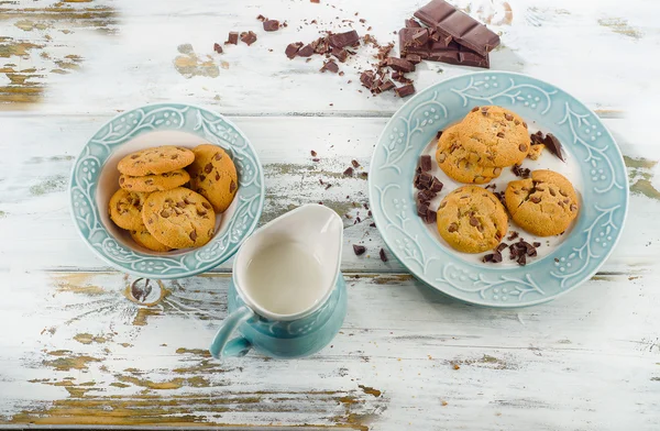 Chocolate chip cookies with milk in jug — Stock Photo, Image