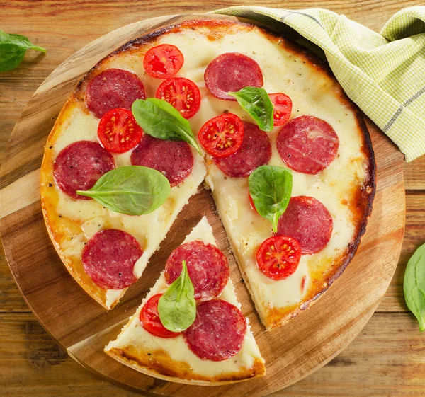 Pizza geserveerd op een houten bord. — Stockfoto