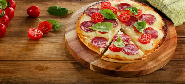 Pizza serviert auf einem hölzernen Hintergrund. — Stockfoto